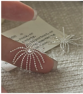 Macro shot of S925 sterling silver firework earrings with micro-set shimmering crystals