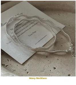 Détail macro du collier vagues en argent S925 avec texture métallique brossée