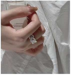 Detailed close-up of S925 silver lace texture ring held against a perfume bottle