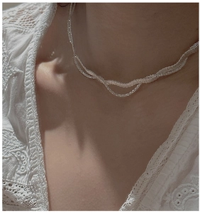 Gros plan sur un collier ras du cou en dentelle blanche tressée pour un look vintage chic