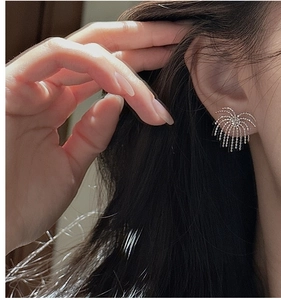 Detailed close-up of S925 sterling silver tassel firework earrings on a model