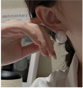 Detailed close-up of S925 sterling silver earring with a unique hammered texture finish
