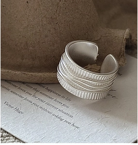 Détail d'une bague large en argent S925 avec plis verticaux et décorations en fil de fer