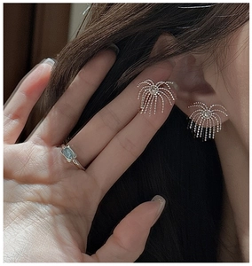 Detail view of S925 sterling silver tassel firework earrings and light blue gemstone ring