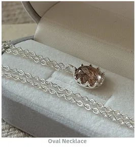 Macro view of an oval rutilated quartz pendant on a silver S925 chain in a velvet box
