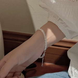 Elegant S999 sterling silver shimmering bracelet on woman's wrist with lace blouse