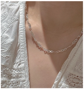 Close-up of S925 sterling silver infinity link necklace worn on model neck