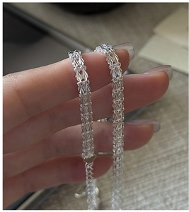 Détail macro du bracelet en argent S999 avec texture tissée facettée et polissage brillant