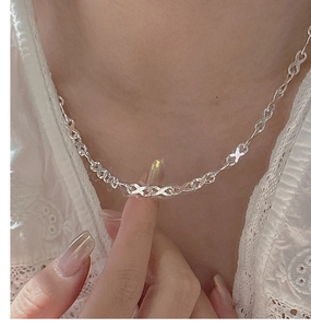 Detailed close-up of a sterling silver infinity link necklace worn by a model
