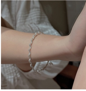 Detail of S925 sterling silver twisted rope bracelet worn on wrist with lace sleeve