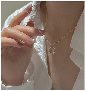 Macro shot of S925 silver necklace with an oval rutilated quartz pendant on a model
