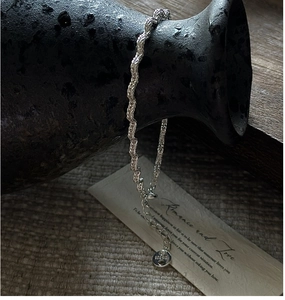 Macro detail of S925 sterling silver twisted rope chain with lobster clasp and tag