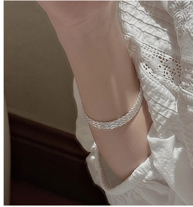 Detailed close-up of S999 sterling silver multi-strand braided shimmering bracelet