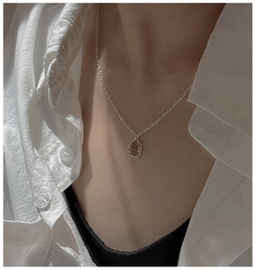 Detailed close-up of a silver-toned S925 necklace featuring a textured round relief pendant