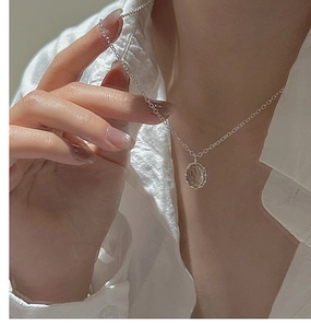 Close-up of minimalist S925 silver necklace with an oval rutilated quartz gemstone pendant