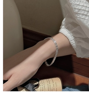 Vue détaillée d'un bracelet chaîne tressé en argent avec une texture tissée vintage