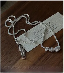 Macro detail of S925 sterling silver chain with three irregular organic circular pendants