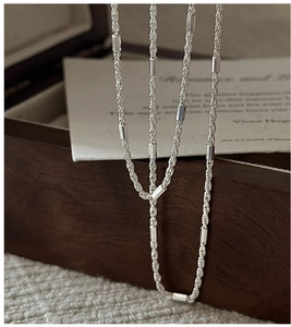 Detailed close-up of a S925 sterling silver twisted rope chain necklace with metal tubes