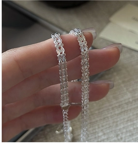 Gros plan d'une chaîne en argent S999 avec texture en feuilles et cœurs décoratifs
