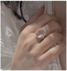 Detail of S925 sterling silver ring with oval clear crystal and milgrain edge decoration