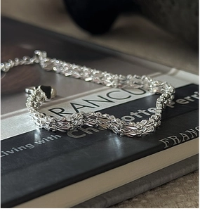 Vue détaillée du bracelet tressé en argent S999 avec une finition miroir polie