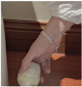 Detail of silver S999 woven chain bracelet with adjustable extender on female wrist