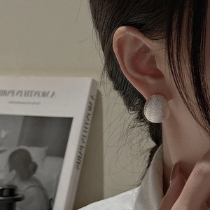 Minimalist S925 sterling silver earring with brushed mesh texture worn by a fashion model