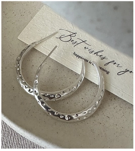 Detail of S925 sterling silver hoop earrings with vintage hammered texture and matte finish