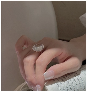 Close-up of vintage S925 silver ring featuring a large oval white crystal on model hand