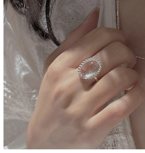 Macro view of vintage S925 sterling silver ring with oval white crystal and lace detail