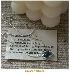 Detail shot of a square blue gemstone pendant on a S925 sterling silver chain necklace