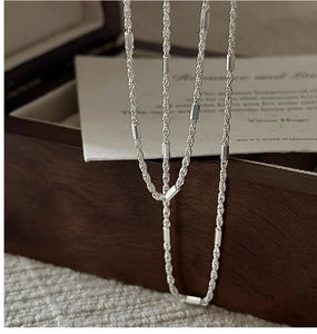 Detail of S925 sterling silver twisted rope chain with polished cylindrical beads decoration