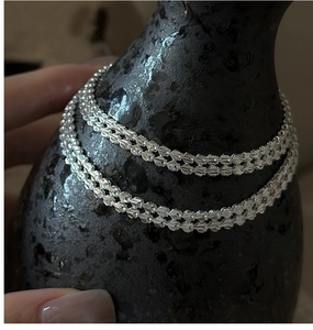 Detailed macro view of S999 silver chain with laser-cut glitter texture on black ceramic