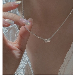 Close-up of a minimalist S925 sterling silver tube pendant necklace on a model neck