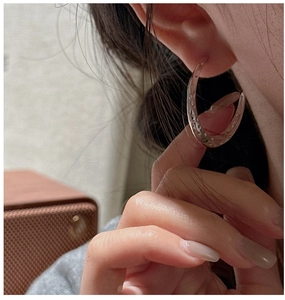 Detailed macro view of S925 silver hoop earrings with vintage hammered texture finish