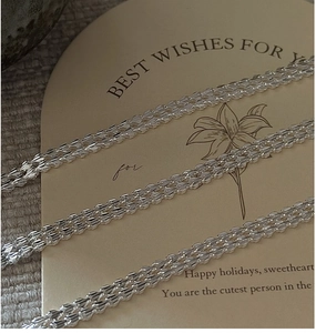 Macro detail of S999 sterling silver bracelet with laser-cut woven wheat chain texture