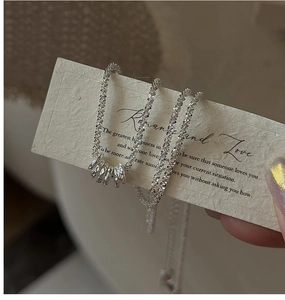 Detail of S925 sterling silver necklace featuring irregular textured rings and a shimmering chain