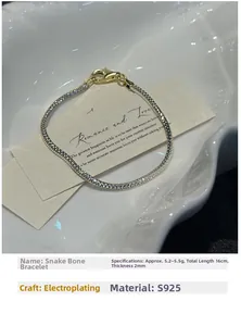 Detail of S925 sterling silver snake chain bracelet with contrast gold clasp closure