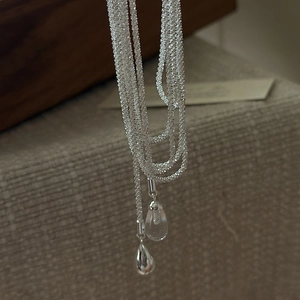 S925 silver multi-layer necklace with clear crystal waterdrop pendant on beige fabric