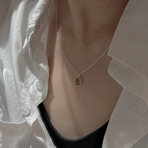 Minimalist S925 sterling silver necklace featuring a vintage oval coin pendant on a model