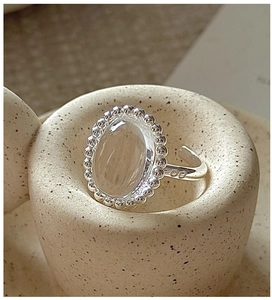 Macro detail of S925 silver ring featuring an oval crystal and beaded edge craftsmanship