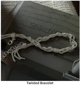Macro shot of silver multilayer woven bracelet with lobster clasp and tassel chain