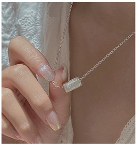 Dettaglio della collana in argento S925 con pendente a cilindro spazzolato su modella