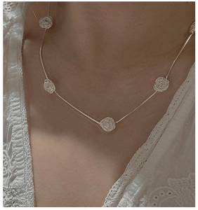 Detailed view of S925 silver rose flower necklace worn on neck with white lace dress