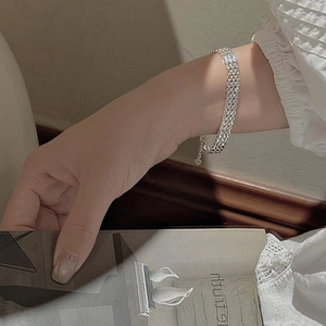 Sparkling S999 sterling silver multi-strand woven bracelet with heart charm on wrist