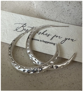 Detailed close-up of S925 sterling silver hoop earrings with unique hammered texture