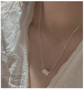 Dettaglio collana in argento S925 con pendente cilindrico opaco indossato sul collo