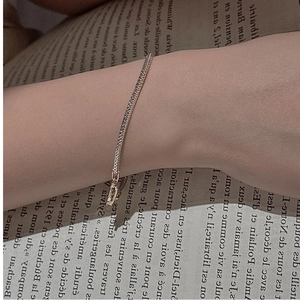 Detail of silver tennis bracelet with white zircons worn against vintage book pages