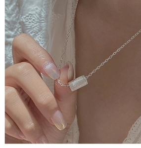 Dettaglio della collana in argento S925 con un ciondolo cilindrico dalla trama opaca