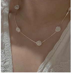 Close-up of S925 sterling silver necklace featuring five delicate 3D rose pendants